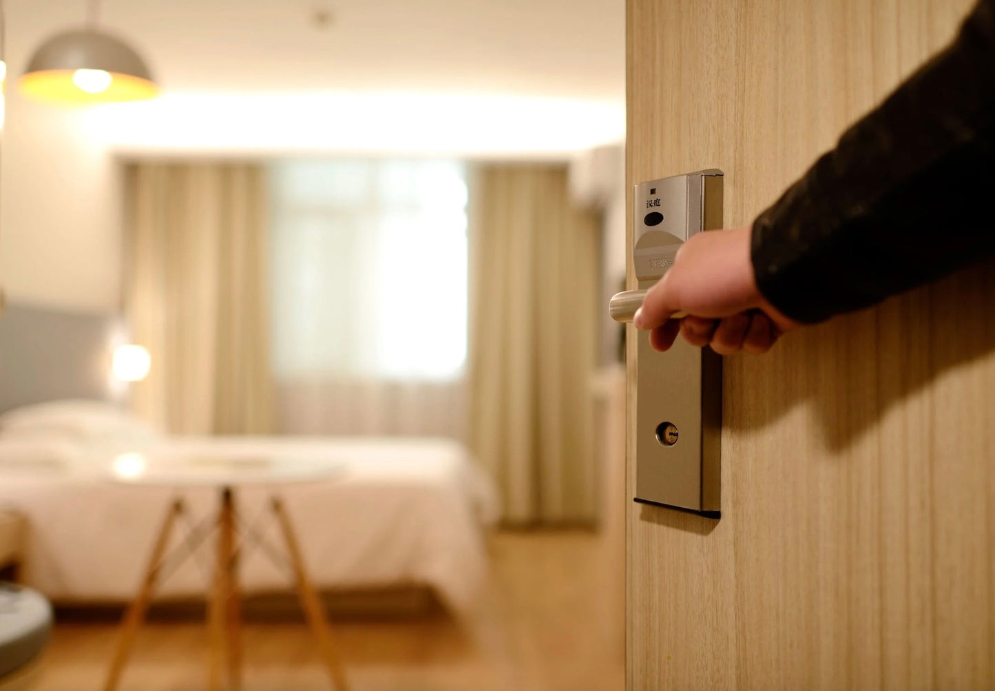Someone opening the door to a hotel room. 