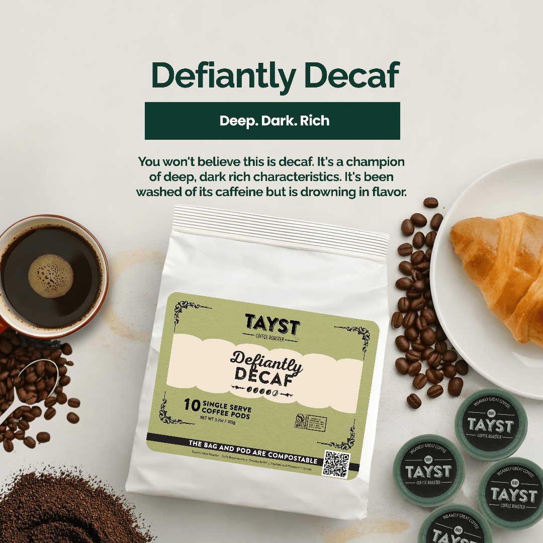 TAYST Defiantly Decaf coffee package with coffee beans, a cup of coffee, and a croissant on a white background.