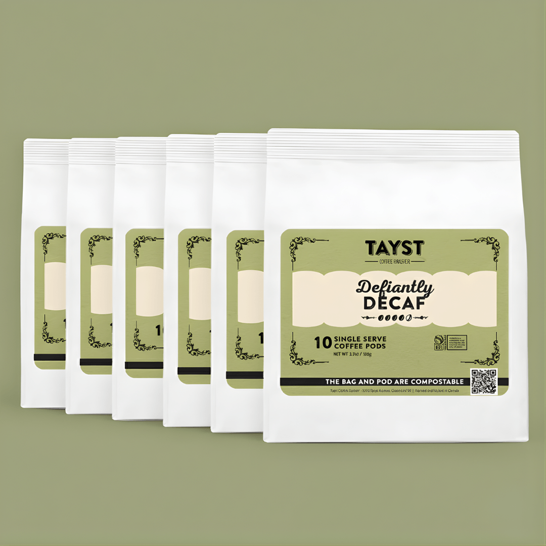 Six pack of Tayst Defiantly Decaf coffee pods on a green background