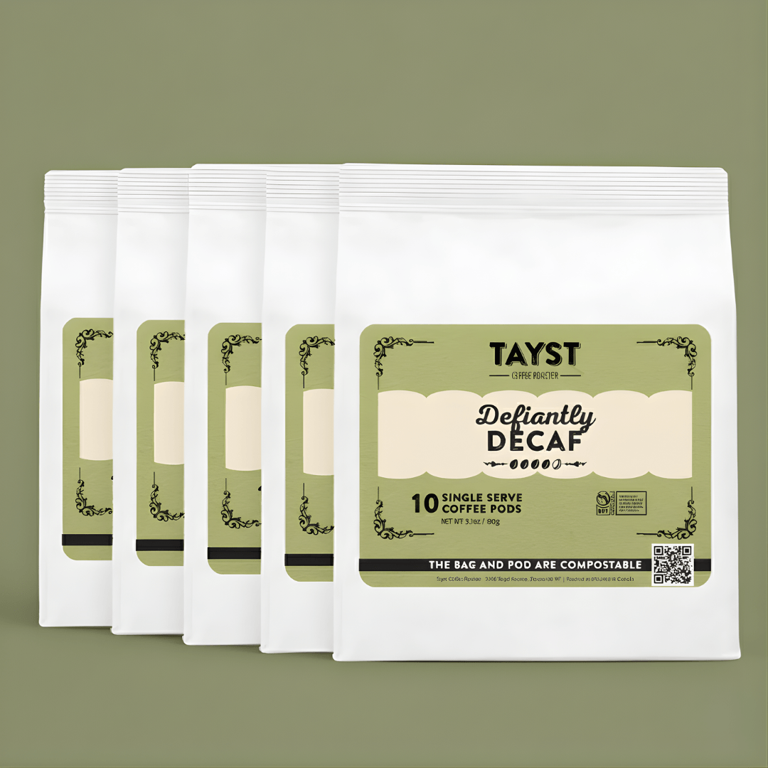Five pack of Tayst Defiantly Decaf coffee pods on a green background