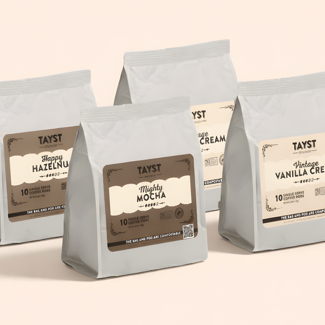 Four Tayst coffee bags with various flavors on a beige background