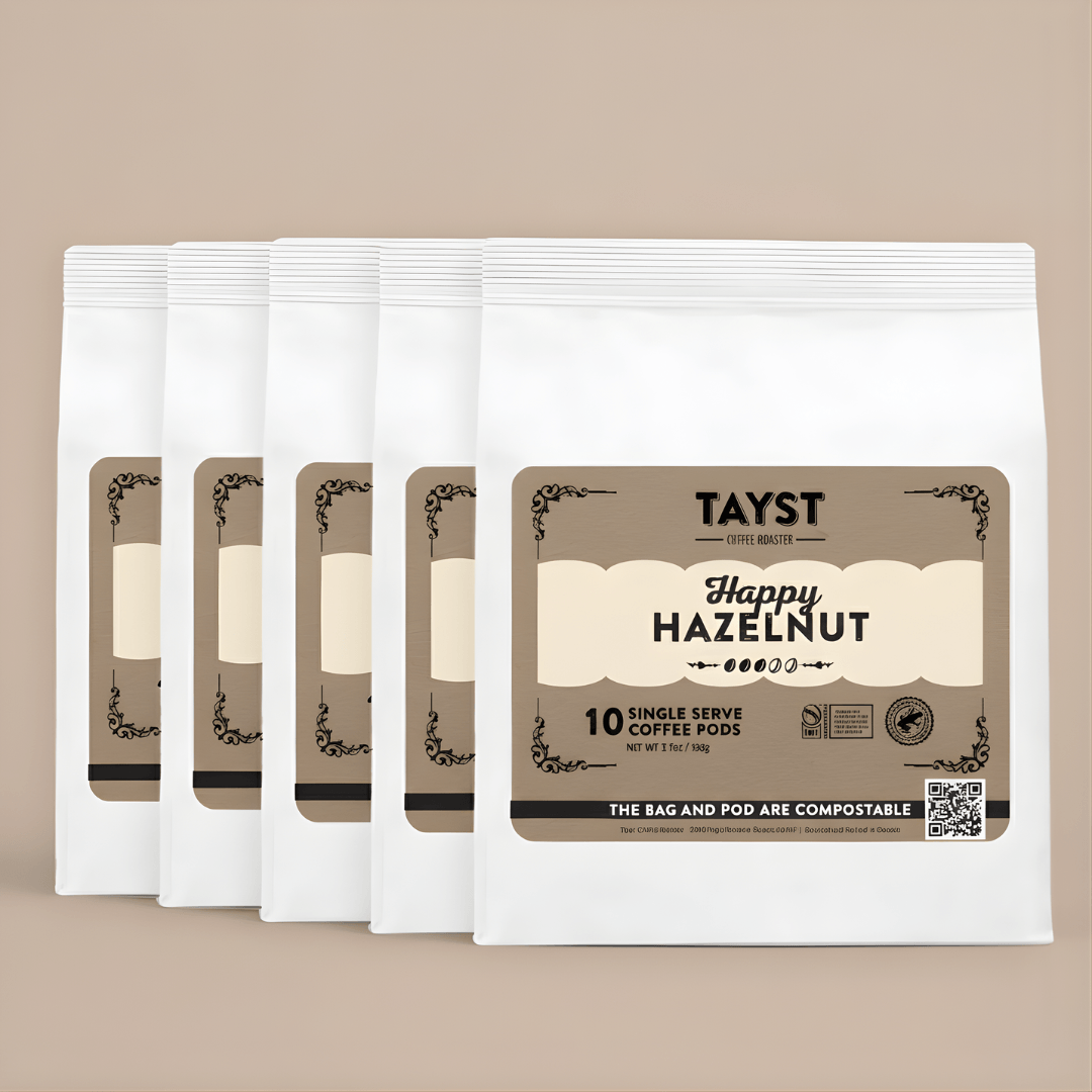 Pack of Tayst Happy Hazelnut single serve coffee pods on a beige background
