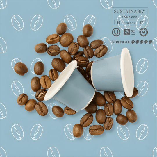 Tayst nespresso capsules and two paper cups on a blue background with coffee bean patterns.