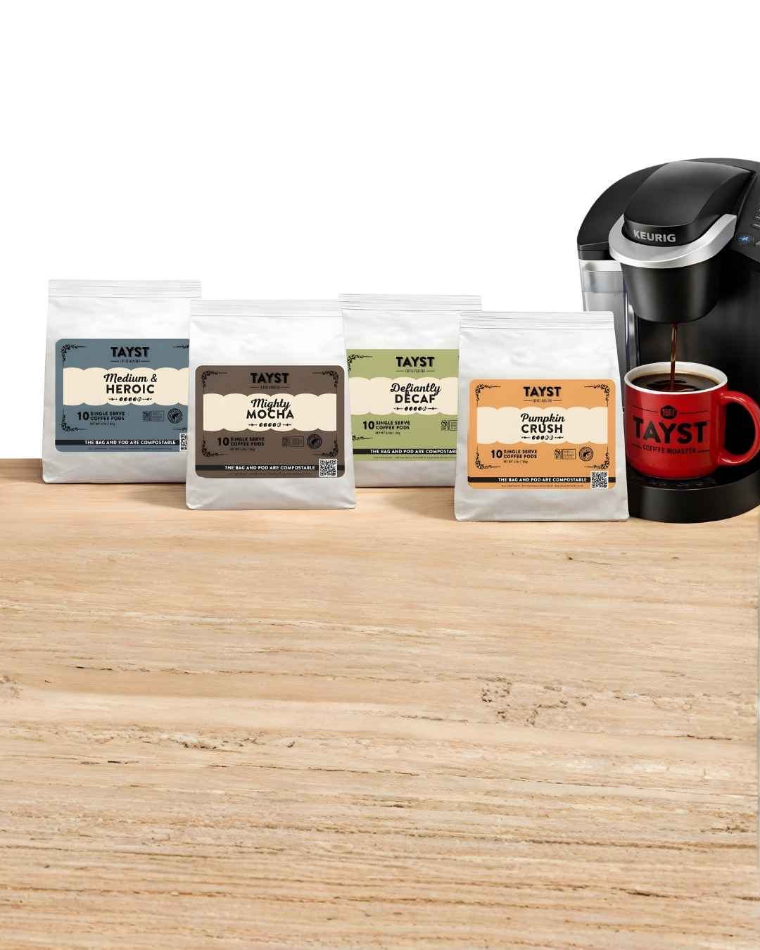 K-cup coffee pods and a Keurig machine on a wooden surface with a white background