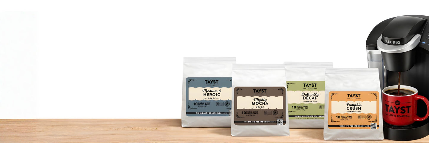 K-cup coffee pods and a Keurig machine on a wooden surface with a white background